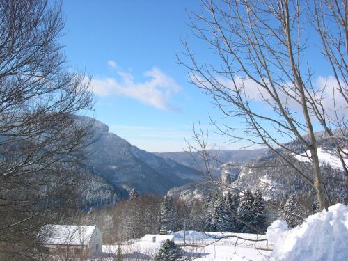 a view of a snow covered valley with mountains at Auberge des Montauds - Hôtel & Restaurant in Villard-de-Lans