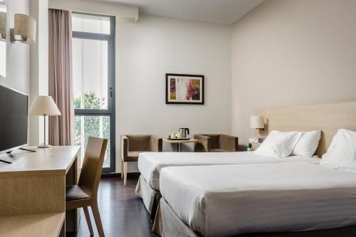 サン・ホアン・デスピにあるホテル エグゼ バルセロナ ゲートの大きなベッドとデスクが備わるホテルルームです。