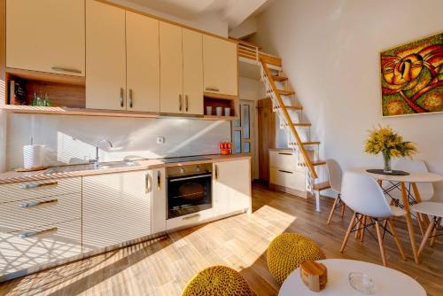 a kitchen with a staircase and a table and chairs at 42° North Apartments in Tivat