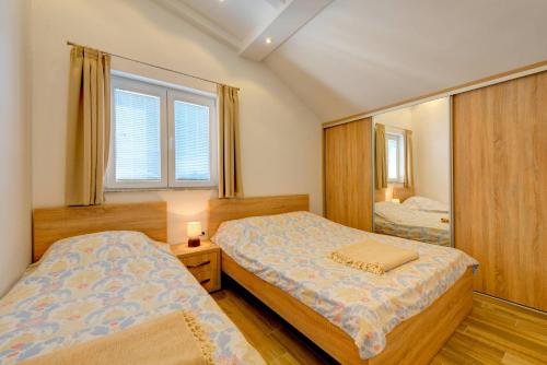 a bedroom with two beds and a mirror at 42° North Apartments in Tivat