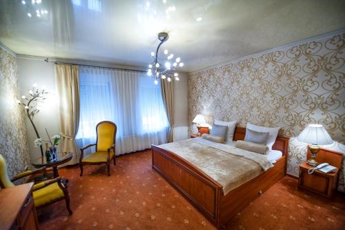 a bedroom with a large bed and a desk and chairs at Hotel Imperium in Piekary Śląskie