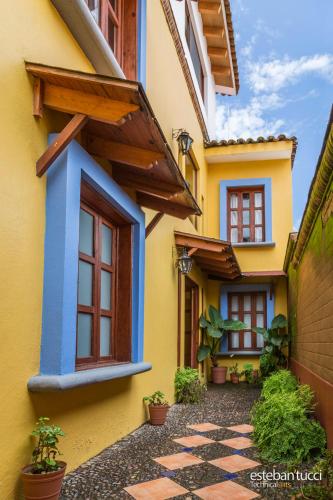 a yellow and blue house with potted plants at Hotel Posada Real Tapalpa in Tapalpa