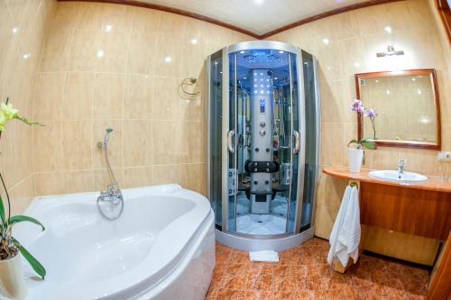 a bathroom with a tub, toilet, sink and shower at Hotel Imperium in Piekary Śląskie
