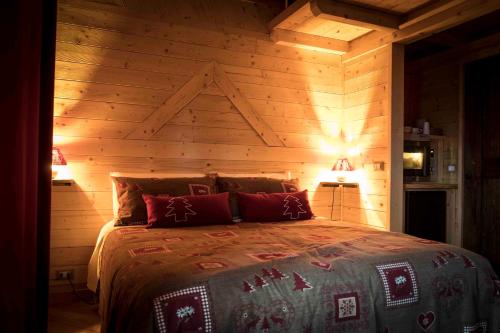 1 dormitorio con 1 cama con pared de madera en Il Nido del Casalot, en Frassino
