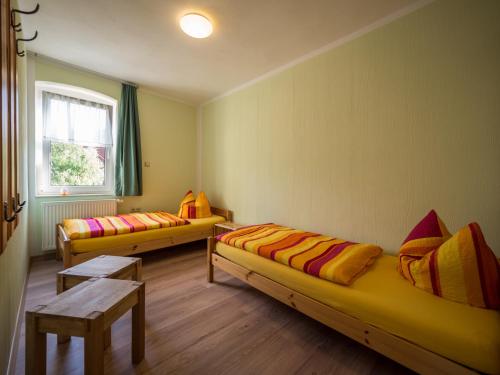 エアフルトにあるFerienwohnung Meiselbachのベッド2台、テーブル、窓が備わる客室です。