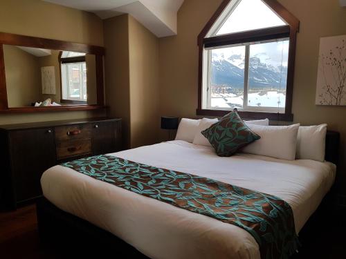 1 dormitorio con 1 cama grande y ventana en PRC Annex - Pet Friendly, en Canmore