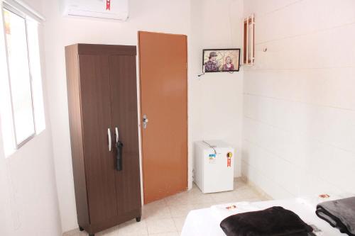 um quarto com uma porta castanha num quarto em Hotel Pousada Farol da Praia em São Luís