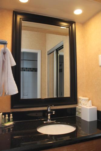 a bathroom with a sink and a large mirror at Best Western Plus Suites Downtown Calgary in Calgary