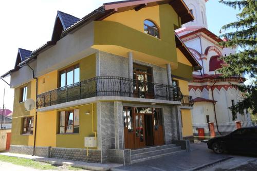 a yellow and white building with a balcony at Class in Petroşani
