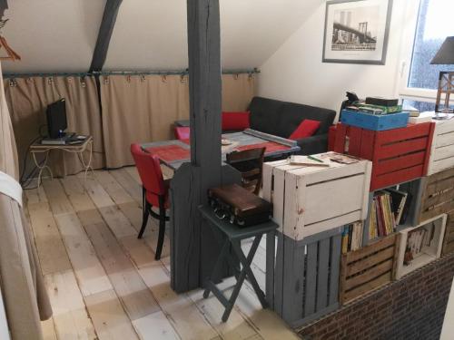 a living room with a stove and a couch at Le Grenier in Les Ageux