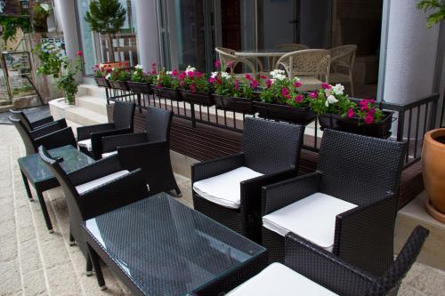 a row of tables and chairs on a patio with flowers at Hotel & Rooms Lombrelle in Mostar