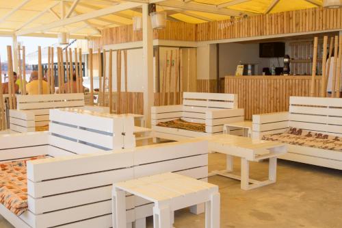 a room with white benches and tables in it at Oasis Belorizonte in Santa Maria