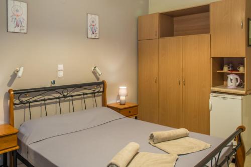 a bedroom with a bed and a refrigerator and a kitchen at Pension Elena in Ágios Nikólaos