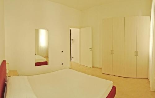 カンピョーネ・デル・ガルダにあるCampione Ora apartments by Gardadomusmeaの白いベッドルーム(ベッド1台、鏡付)