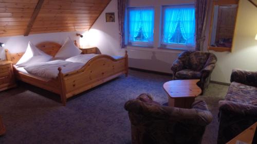 a bedroom with a bed and a couch and a chair at Landgasthof Rademacher in Finnentrop