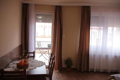 a living room with a dining room table and a window at Imola és Andrea Apartmanház 2 in Hajdúszoboszló