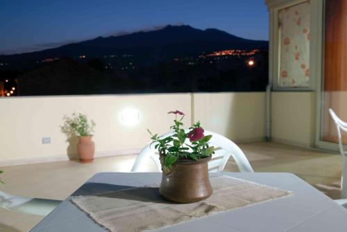 a table with a potted plant on top of a balcony at Le Giare B&B in Riposto