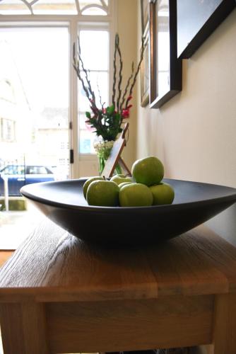 a bowl of fruit sitting on a wooden table at Cotswold House Hotel and Spa - "A Bespoke Hotel" in Chipping Campden