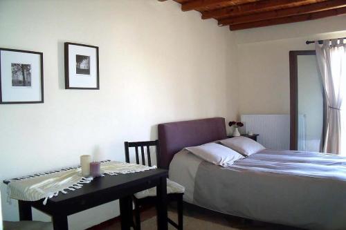 a bedroom with a bed and a table and a chair at Klio Guesthouse in Portaria