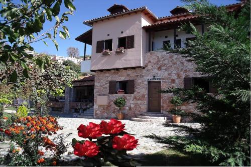 a house with red flowers in front of it at Klio Guesthouse in Portariá