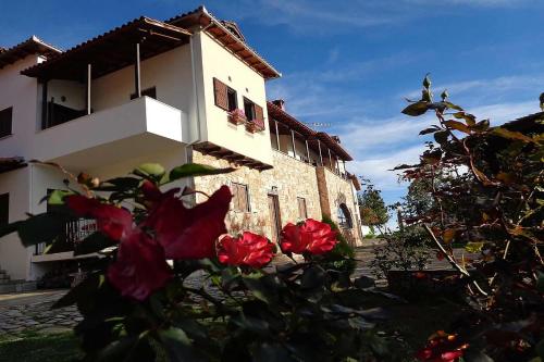 a building with red flowers in front of it at Klio Guesthouse in Portariá