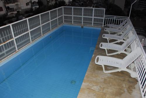 einen Pool mit 2 Liegestühlen und einem Pool in der Unterkunft Ozgun Apart Hotel in Kusadası