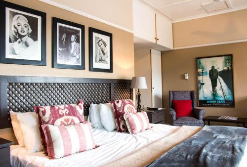 a bedroom with a large bed with red and white pillows at Hallack Manor in Port Elizabeth