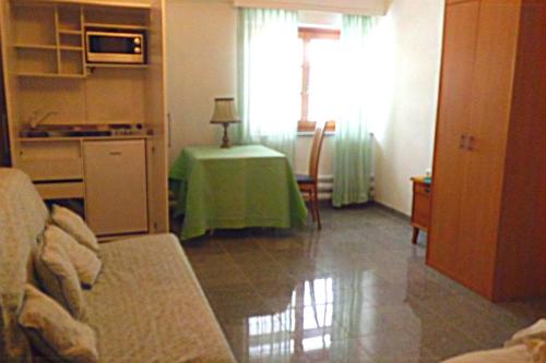 a living room with a green table and a kitchen at Appartement St. Peter a Wimberg in Neufelden