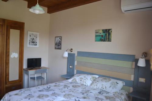 a bedroom with a bed and a desk and a television at B&B Pane e Rose in San Miniato