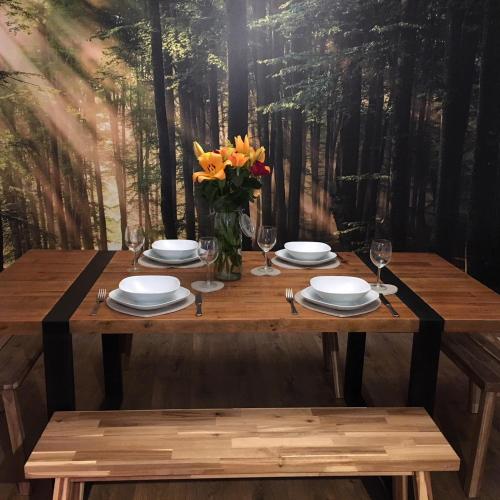 a wooden table with plates and a vase of flowers at Country Nest in Carnwath