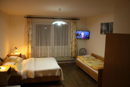 a hotel room with two beds and a tv at Penzion U Králíků in Kurdějov
