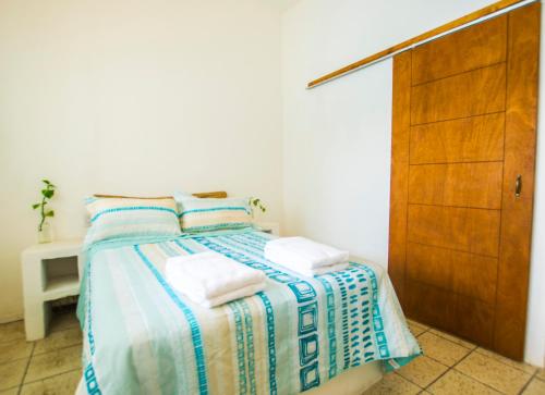 a bedroom with a bed with two towels on it at Casa Pancho Playa in San Francisco