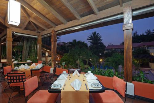 a restaurant with tables and chairs on a patio at Country Inn & Suites by Radisson, San Jose Aeropuerto, Costa Rica in San José