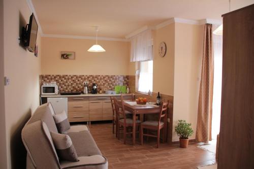 a kitchen and living room with a table and chairs at Imola és Andrea Apartmanház 2 in Hajdúszoboszló