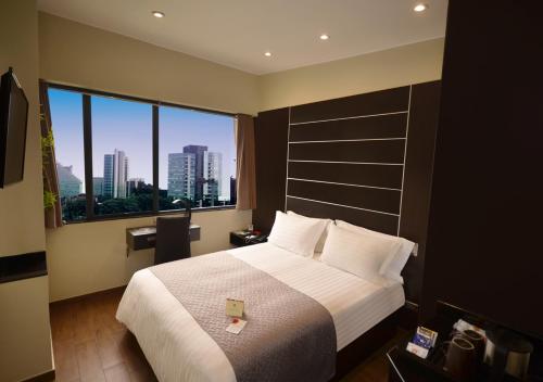 a hotel room with a large bed and a large window at qp Hotels Lima in Lima