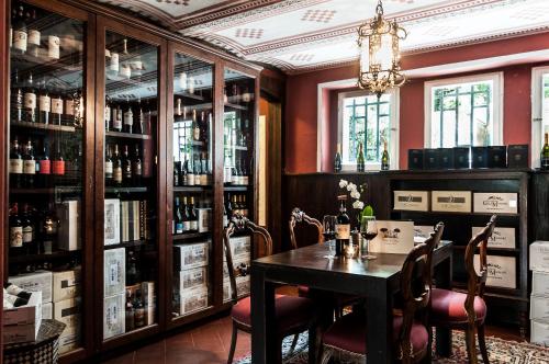 a dining room with a table and some bottles of wine at Hotel Club i Pini - Residenza d'Epoca in Versilia in Lido di Camaiore