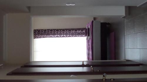 a window with a curtain in a bathroom with a sink at Rex Apartman in Hajdúszoboszló