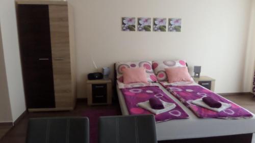 a bedroom with a bed with shoes on it at Rex Apartman in Hajdúszoboszló