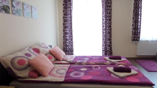 a bed with pillows on it in a bedroom at Rex Apartman in Hajdúszoboszló