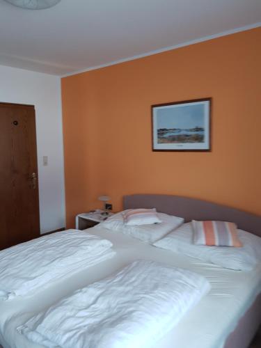 a bedroom with a large white bed with a picture on the wall at Ferienwohnung Stock in Rinn