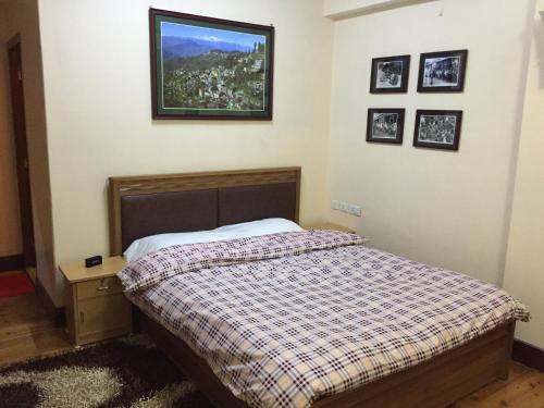 a bedroom with a bed and a picture on the wall at Ki Kiba Dhee in Darjeeling