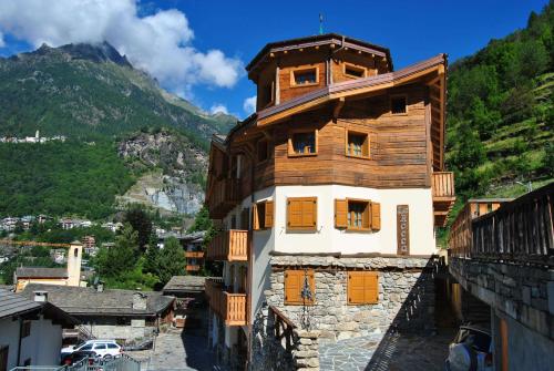 a wooden building with orange doors on a mountain at Casa Vacanza La Rocca in Chiesa in Valmalenco