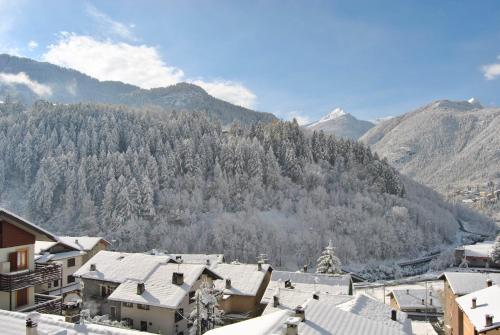 a town with snow covered roofs and a mountain at Casa Vacanza La Rocca in Chiesa in Valmalenco