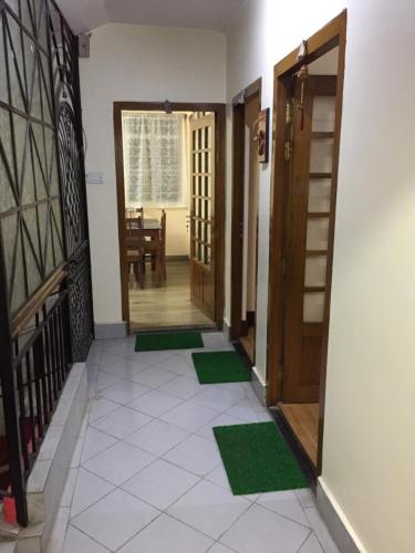 a hallway of a house with green mats on the floor at Ki Kiba Dhee in Darjeeling
