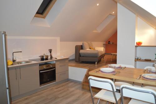 a kitchen and living room with a table and chairs at Appartement calme Le clos de Renée in Hautvillers