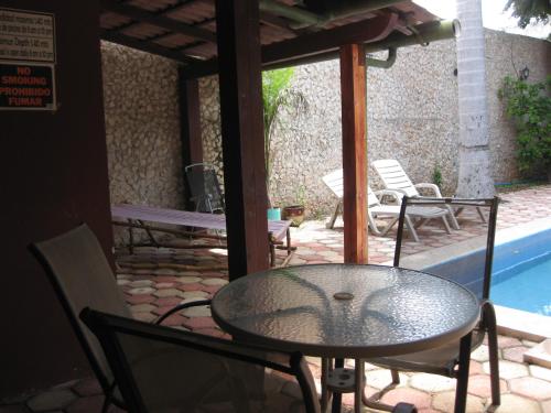 a patio with a table and chairs and a pool at Yucatan Vista Inn Guest House in Mérida
