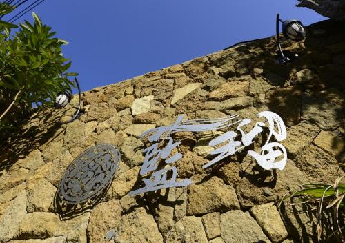 a sign on the side of a stone wall at Balinese onsen ryokan Hakone Airu in Hakone