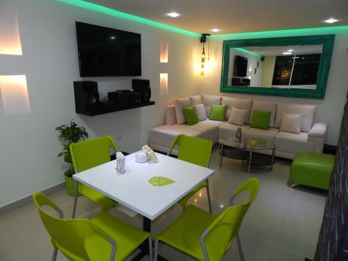 Apartment Lux Bocagrande في كارتاهينا دي اندياس: غرفة معيشة مع أريكة وطاولة وكراسي