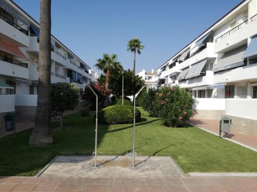 チクラナ・デ・ラ・フロンテーラにあるApto Melkartの芝生の中に柱が二本あるアパートメントの中庭