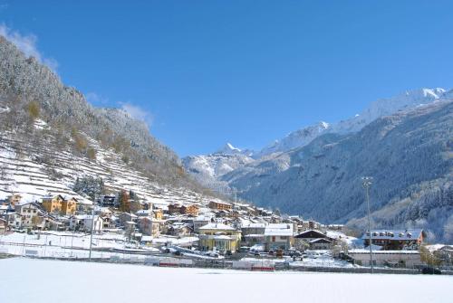 a town in the mountains with snow on the ground at Casa Vacanza La Rocca in Chiesa in Valmalenco